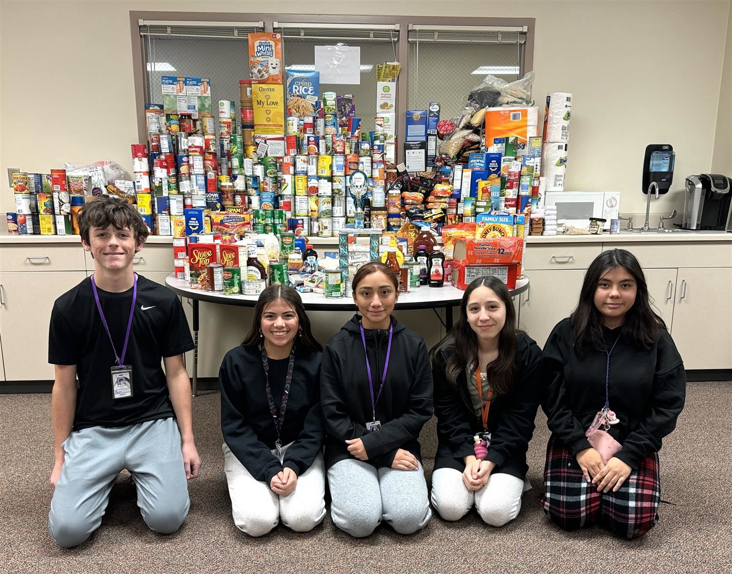 Barr NJHS leaders smiling with 1,1000 donated goods at Barr Middle School.